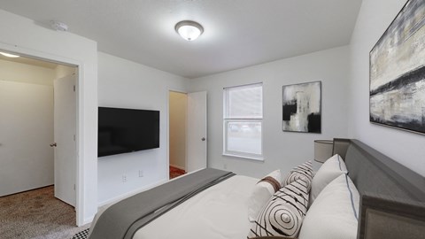 A bedroom with a large bed and a flat screen TV.