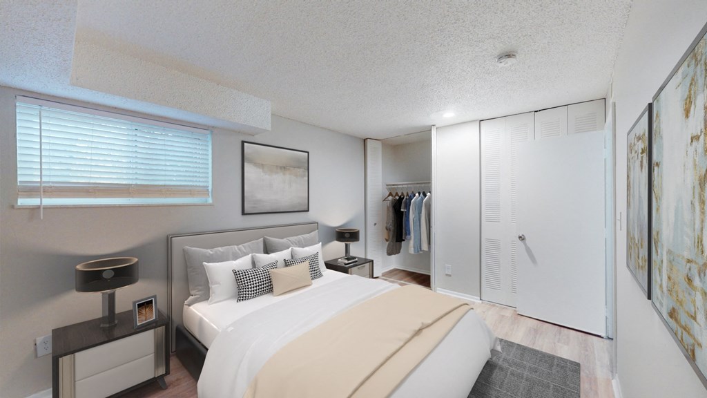 A bedroom with a large bed and a painting on the wall.