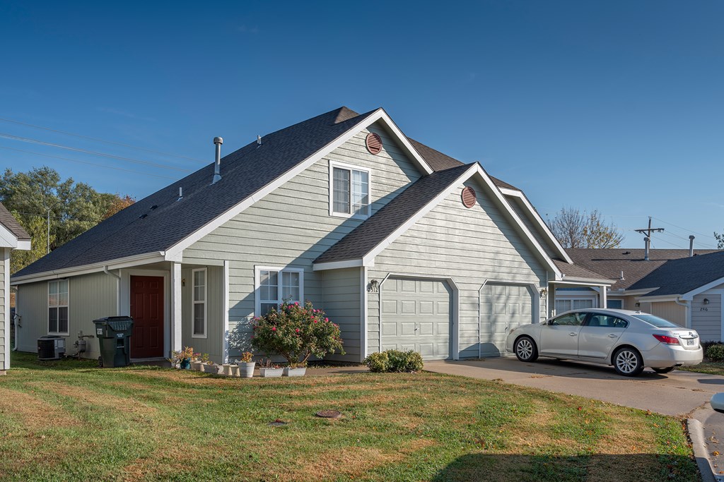 A house with a car parked in front.