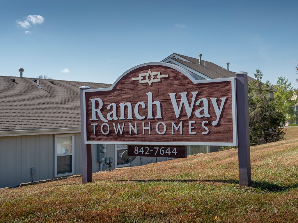 A sign for Ranch Way Townhomes with a phone number on it.