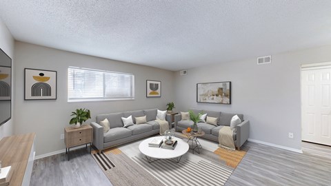 A living room with a grey couch and a coffee table.