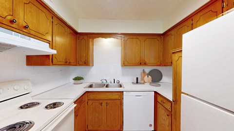 A kitchen with wooden cabinets and white appliances.