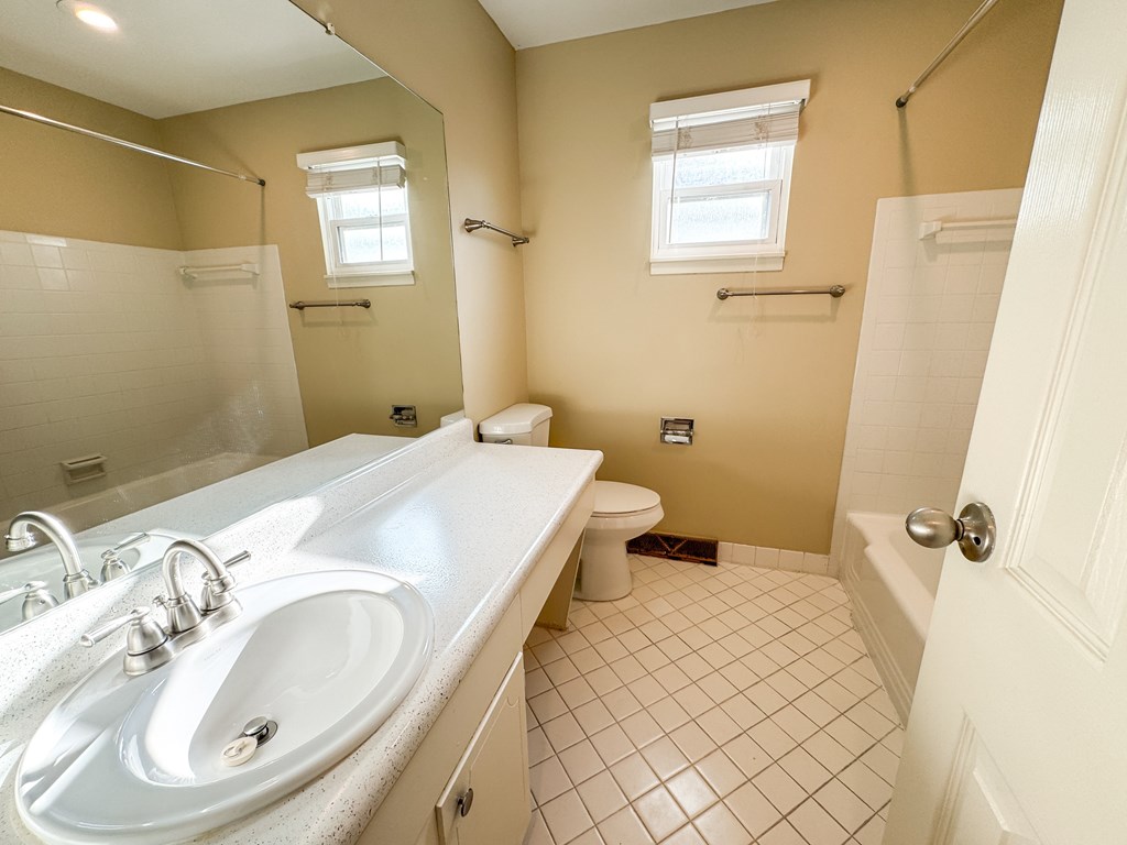 A bathroom with a white sink and a toilet.