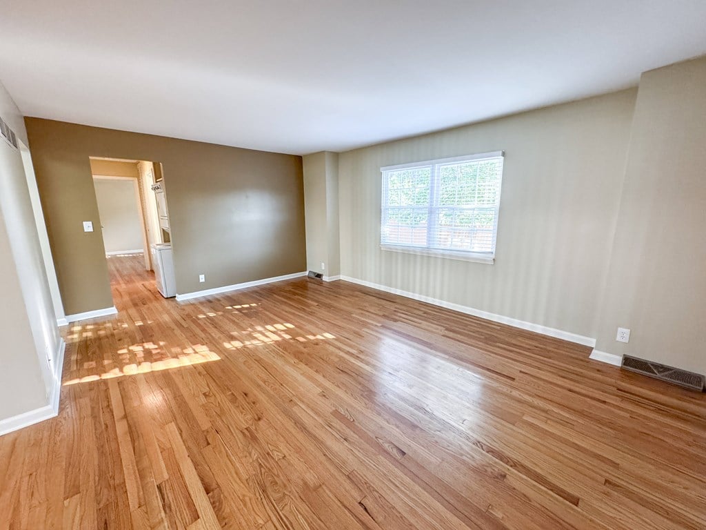 A room with wooden flooring and a window.