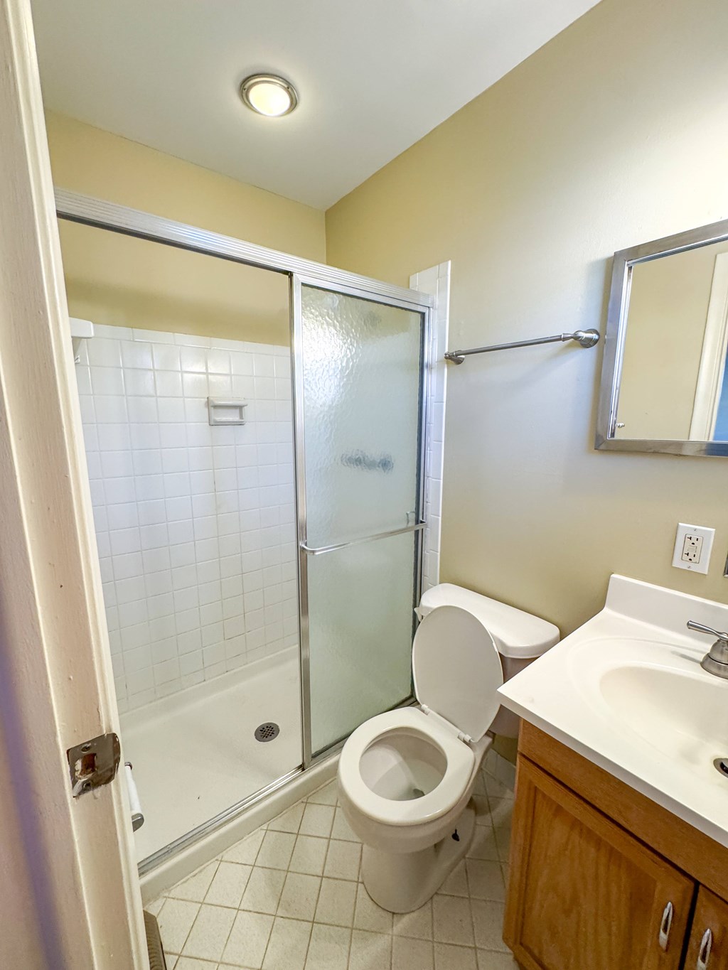 A white toilet is in a bathroom with a walk-in shower.
