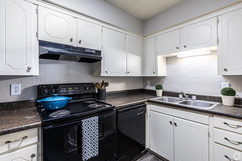 a kitchen with black appliances and white cabinets