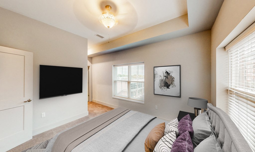 A bedroom with a large bed and a flat screen TV.