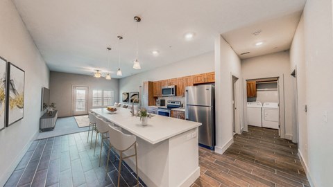 A kitchen with a white island and a refrigerator.