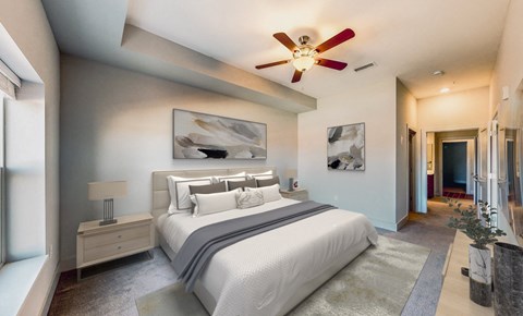 A bedroom with a large bed and a ceiling fan.