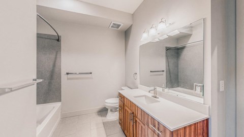 A bathroom with a toilet, sink, and mirror.