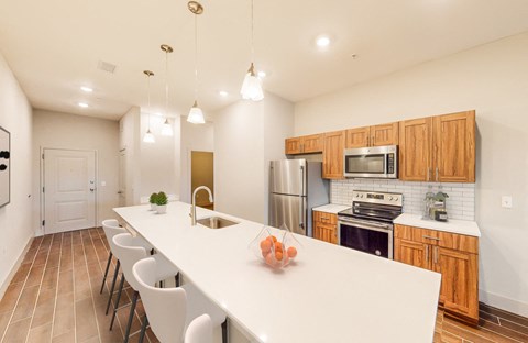 A kitchen with a white counter top and wooden cabinets.