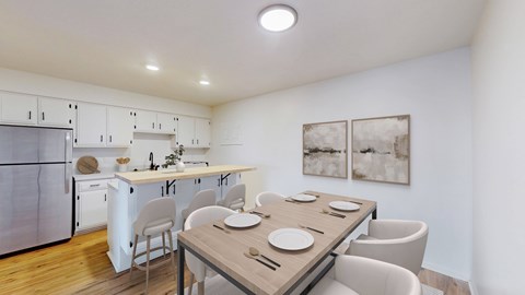 A modern kitchen with a dining table set for two.