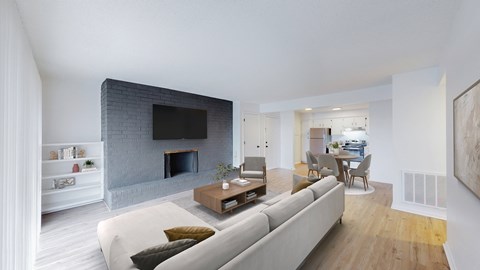 A modern living room with a grey couch and a fireplace.