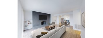 A modern living room with a grey couch and a fireplace.
