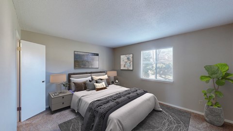 A bedroom with a large bed and a potted plant.