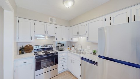 A kitchen with white cabinets and a stove top oven.