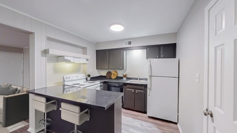 A kitchen with a white fridge and a black counter top.