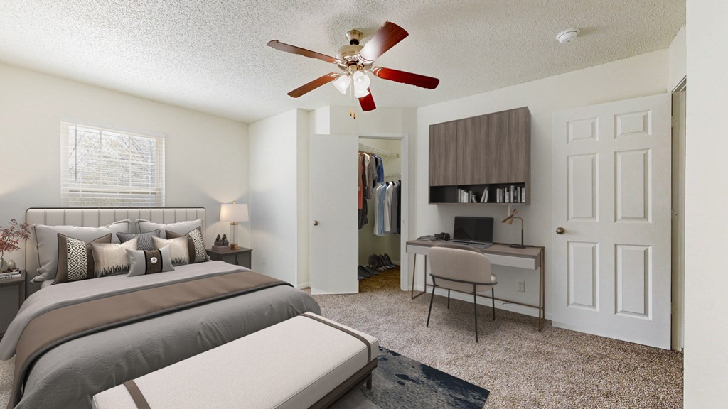 A bedroom with a bed, desk, and a ceiling fan.