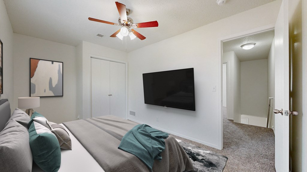 A living room with a grey couch and a black television.