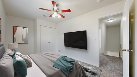 A living room with a grey couch and a black television.