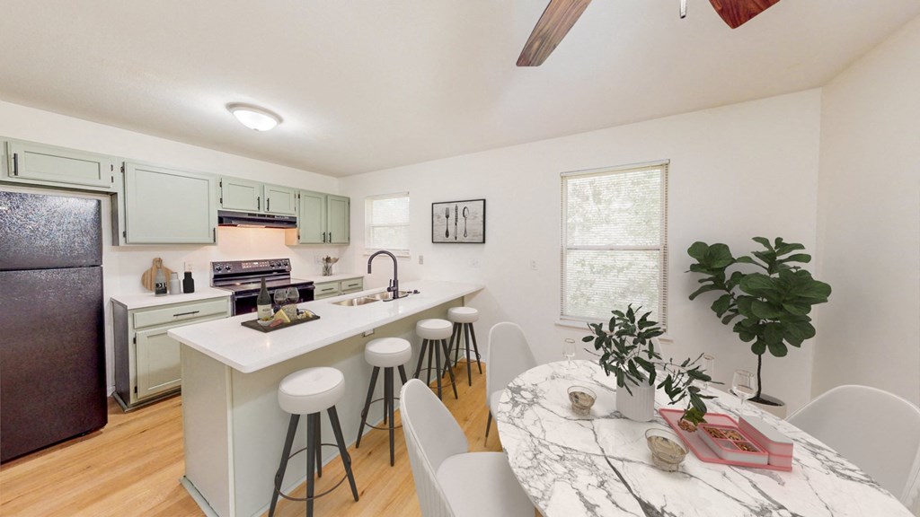 an open kitchen and dining area with a marble counter top
