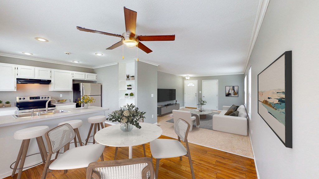 a living room with a kitchen and a ceiling fan