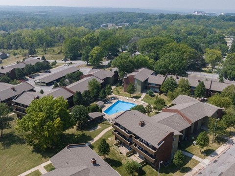 A bird's eye view of a residential area with houses and a swimming pool.