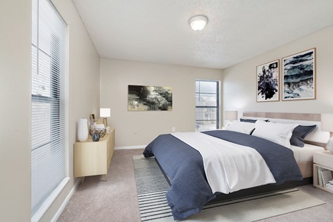 A bedroom with a large bed and a nightstand with a lamp.