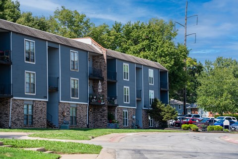 A large apartment complex with a parking lot in front.