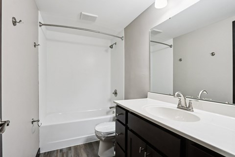 A white bathroom with a toilet, sink, and bathtub.