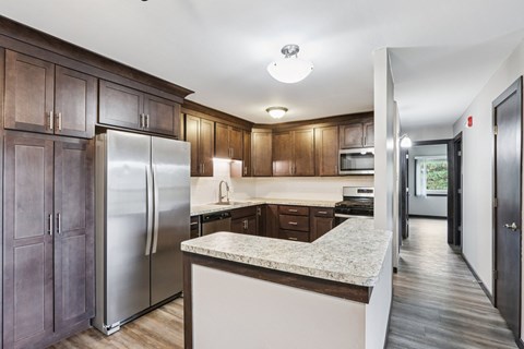 A kitchen with wooden cabinets and a marble countertop.