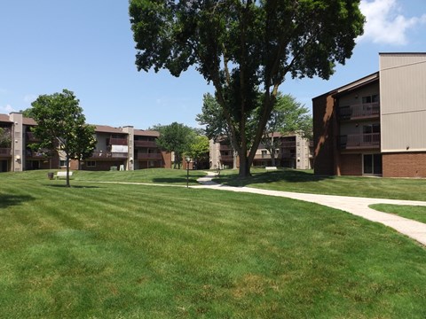 A grassy area in front of apartment buildings.