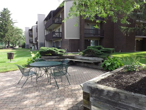 A patio with a table and chairs in front of a building.