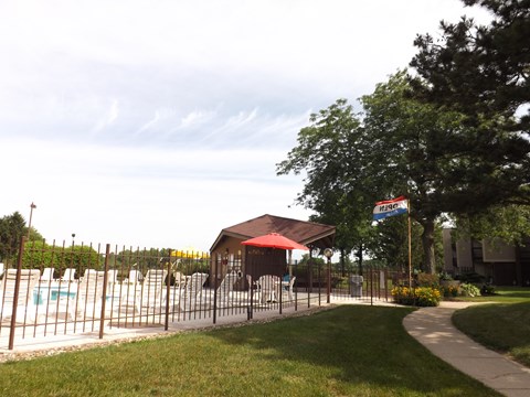 A pool area with a red umbrella and a sign that says "Motel".