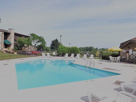 A large swimming pool surrounded by white lounge chairs.