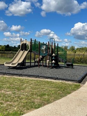 A playground with a green slide and a brown slide.