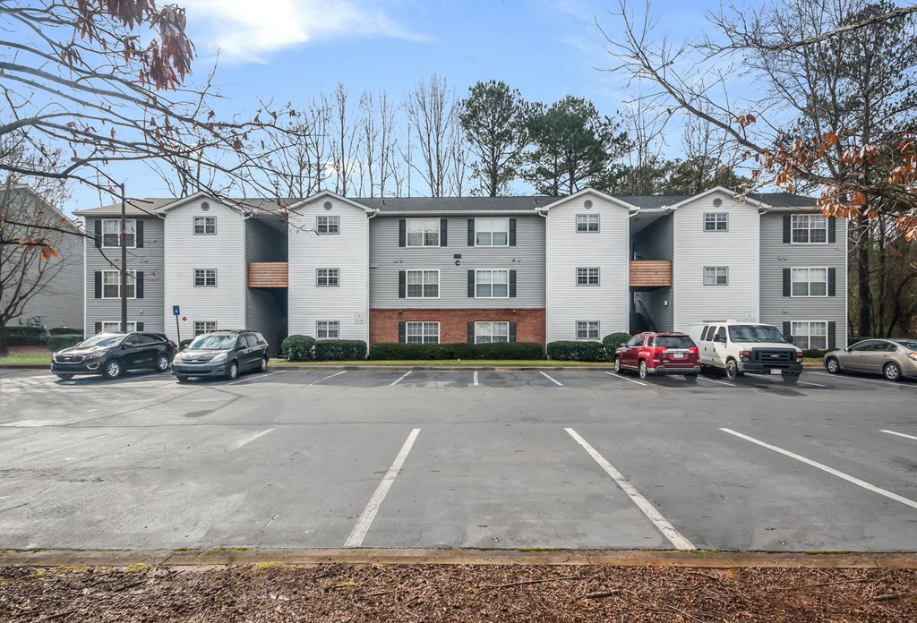 an empty parking lot in front of an apartment building
