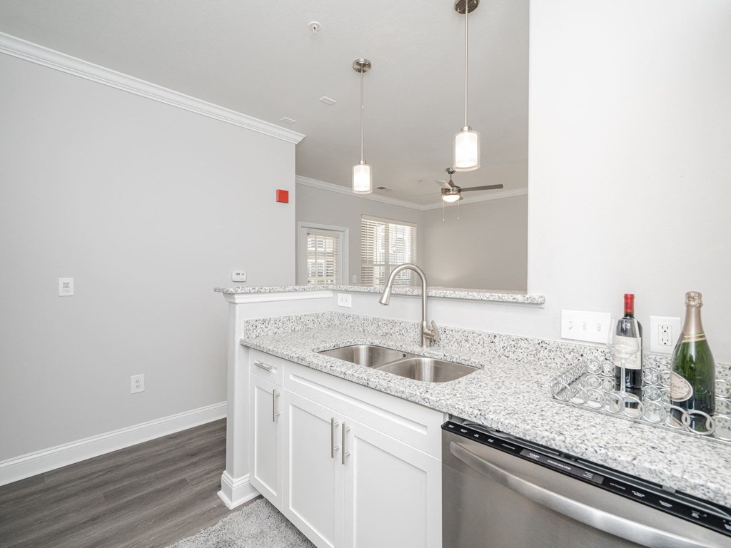 a kitchen with white cabinets and a sink and a dishwasher