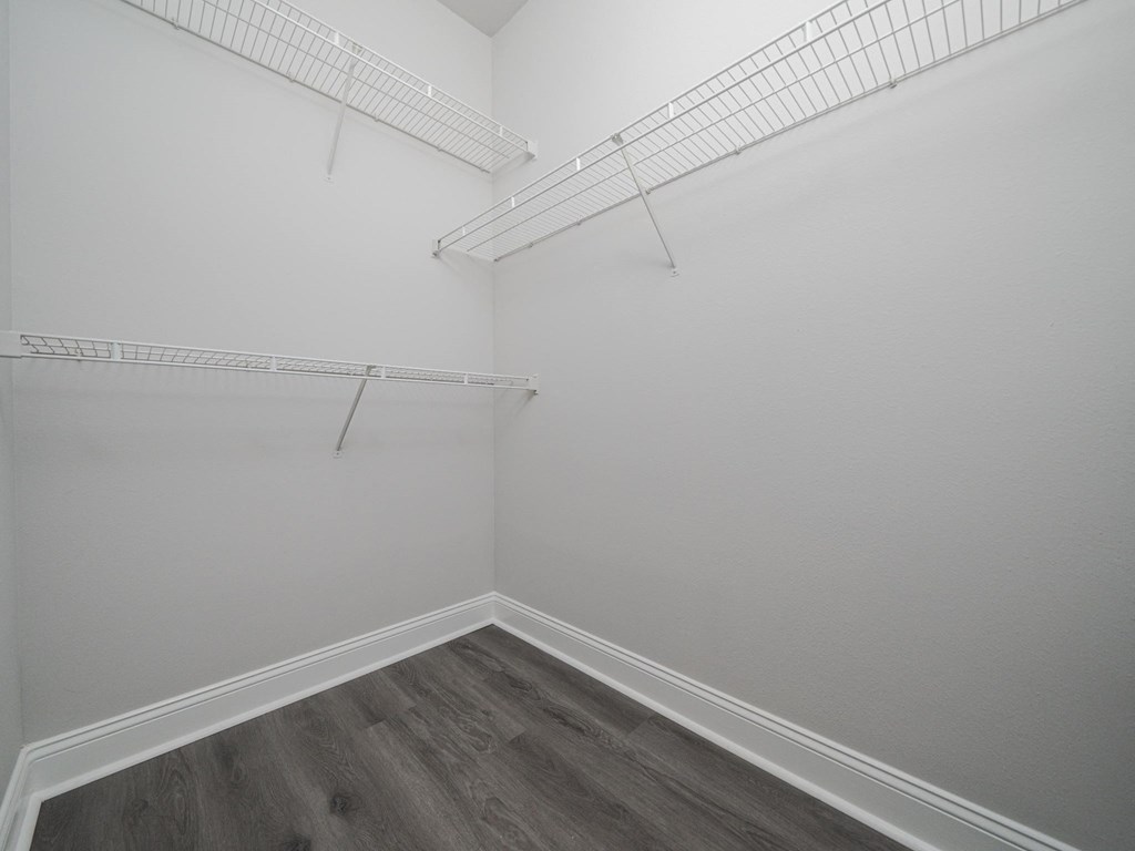 an empty room with white walls and a white closet with shelves