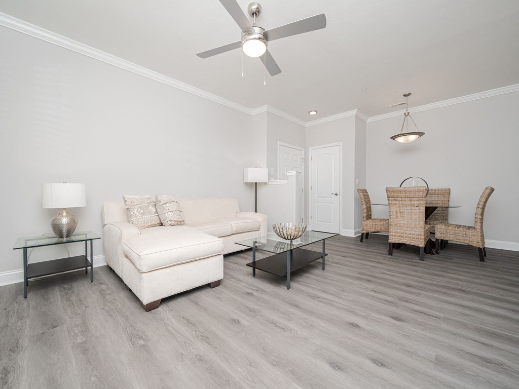 a living room with a white couch and a ceiling fan