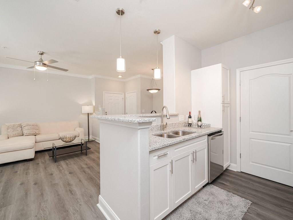 a renovated living room and kitchen with white cabinets