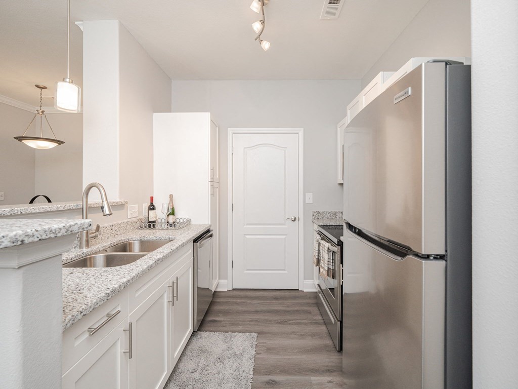 a renovated kitchen with stainless steel appliances and white cabinets