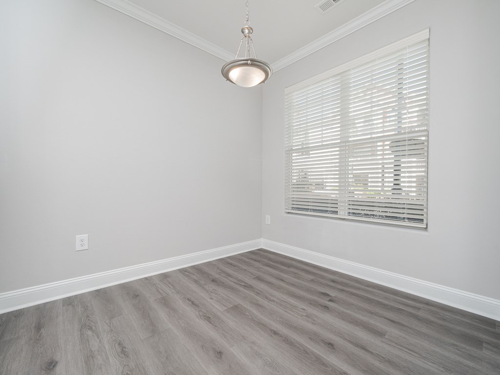 an empty room with wood floors and a window