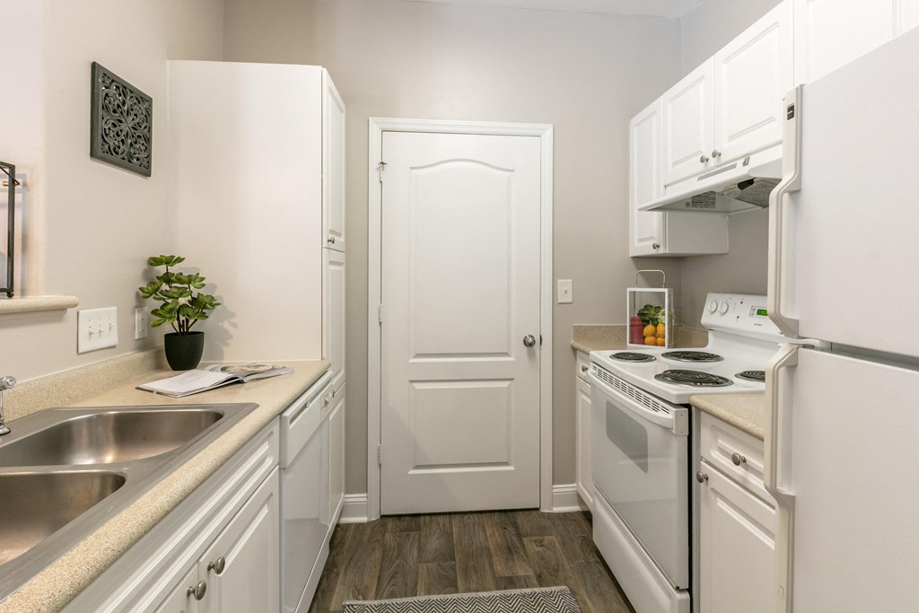 a kitchen with white cabinetry and white appliances