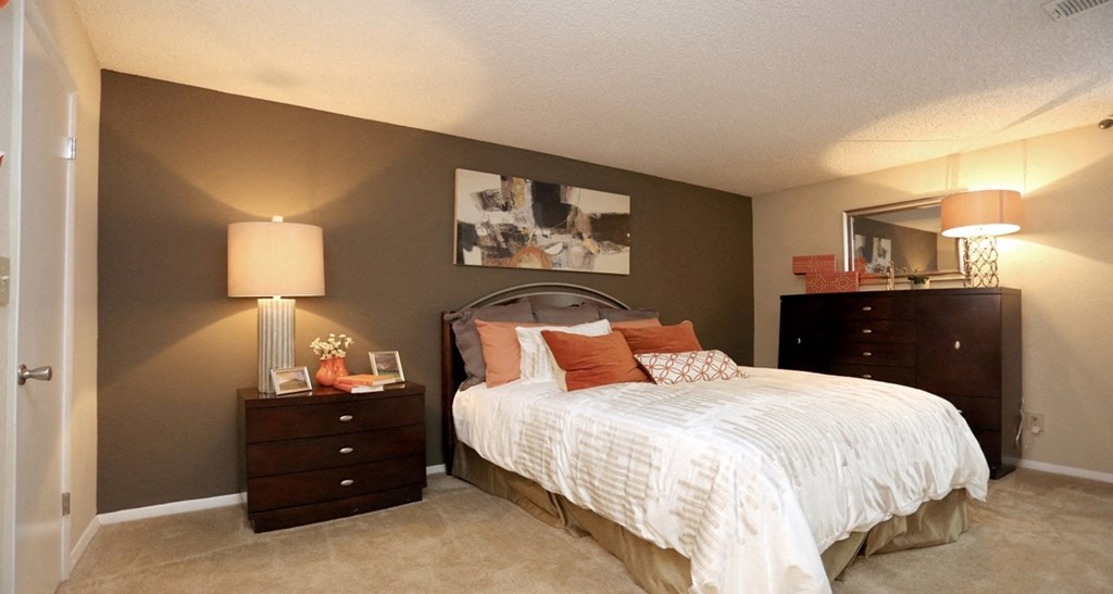 a bedroom with a bed and two dressers