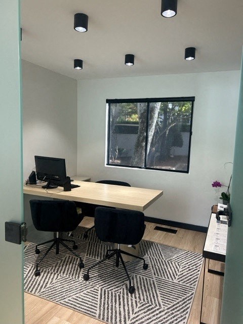 a desk with a computer on it in a room with a window