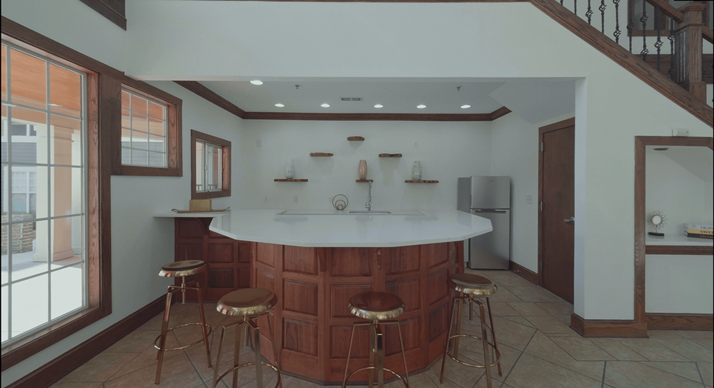 a kitchen with a bar and stools in a house