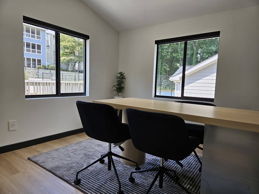 a home office with a desk and a large window