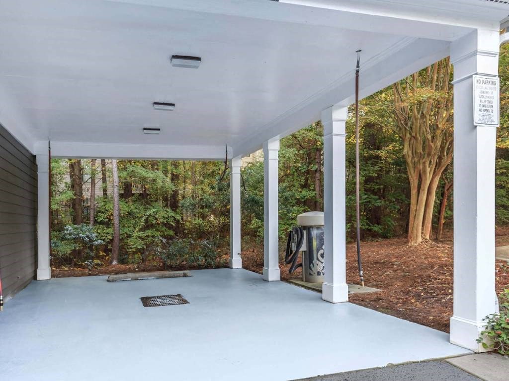 a white porch with a forest in the background