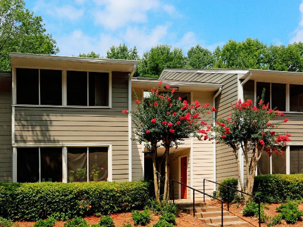 a house with stairs and trees in front of it